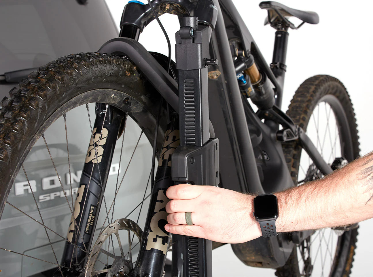 Person adjusting a bicycle with a focus on the front wheel and frame.