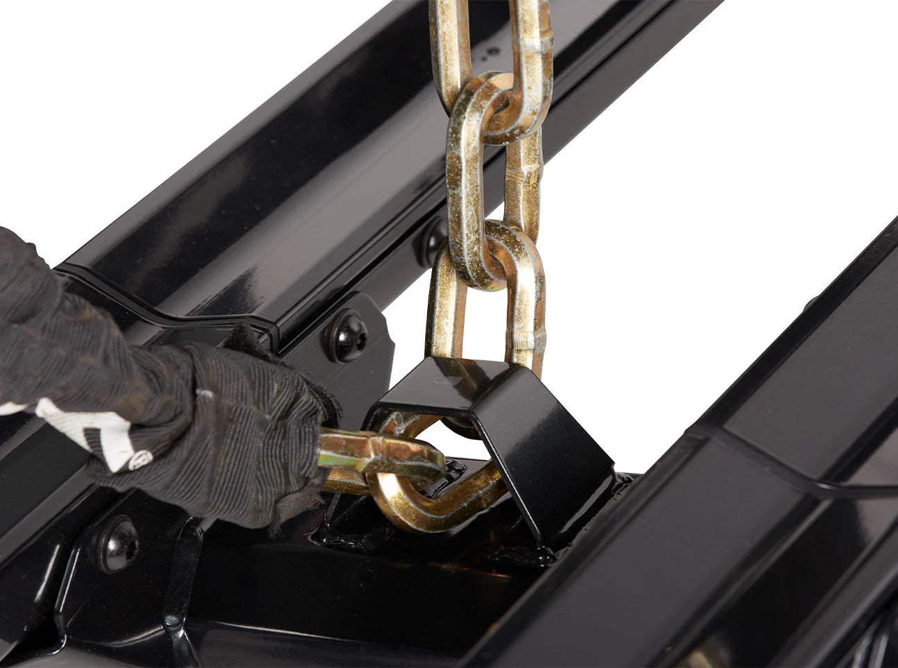Person wearing gloves using a chain to operate a black mechanical device on a white background