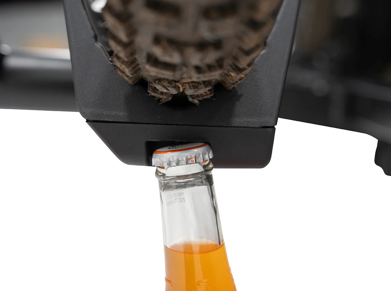Close-up of a bottle cap being removed from a glass bottle using a bottle opener.