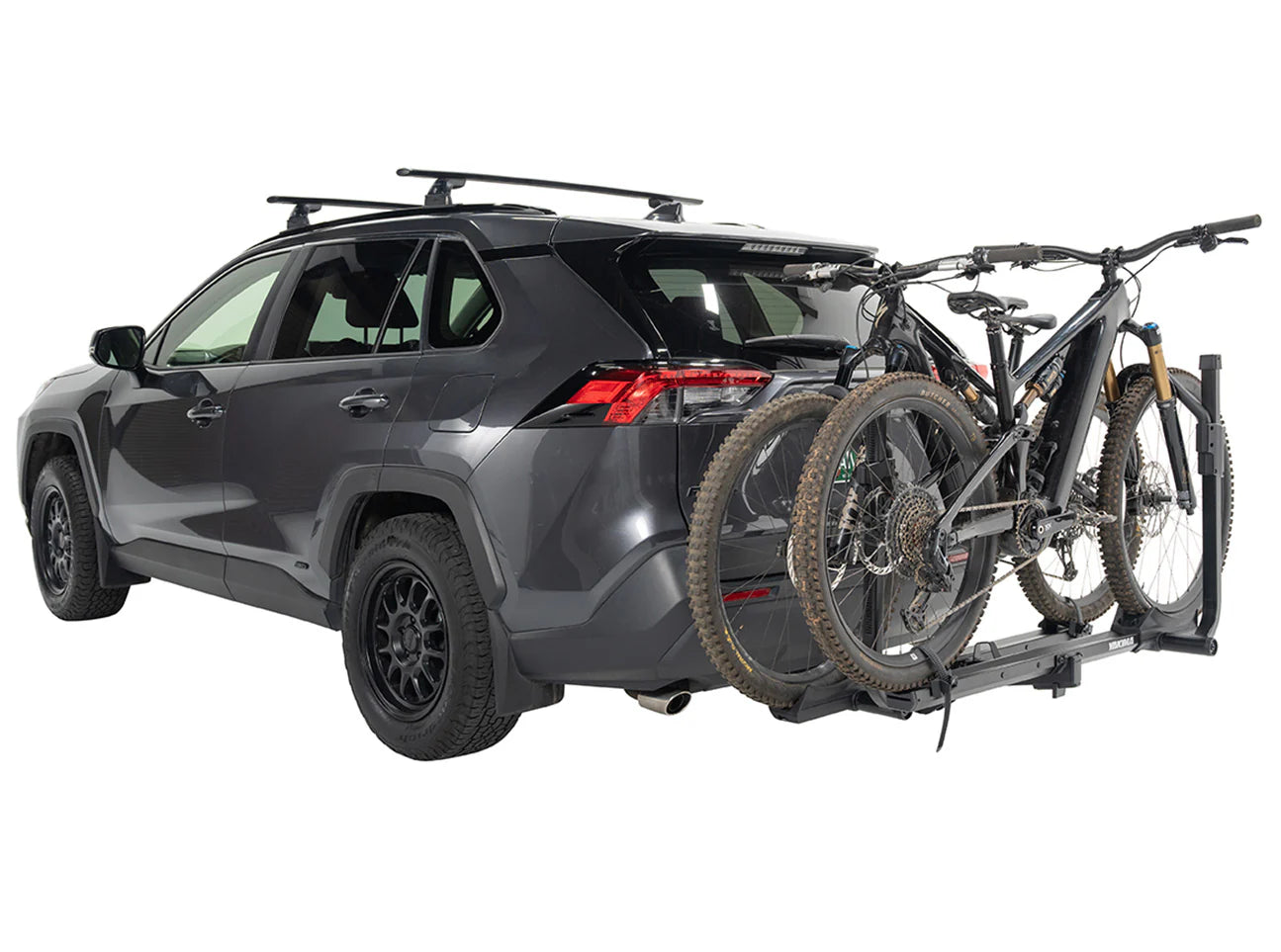 Gray SUV with a bike rack carrying two bicycles on a white background
