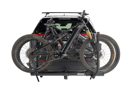 Bicycle rack on a car trunk with two bicycles attached, on a white background
